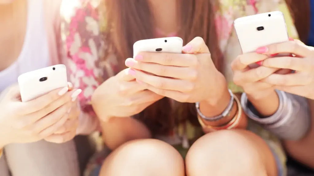 Women on smart phone shows her friend her favorite online brand while she recommends them.