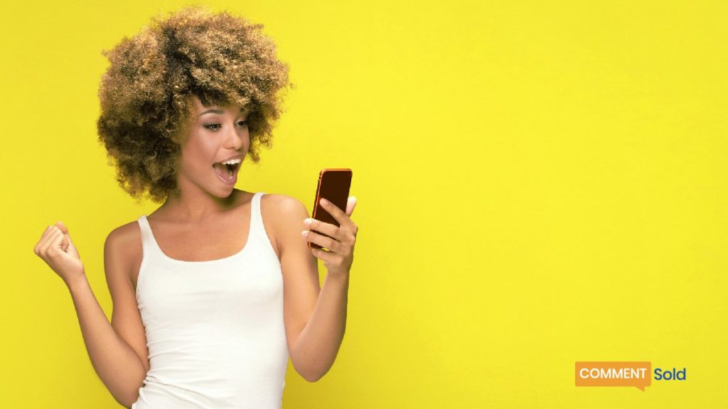woman smiling while looking at phone
