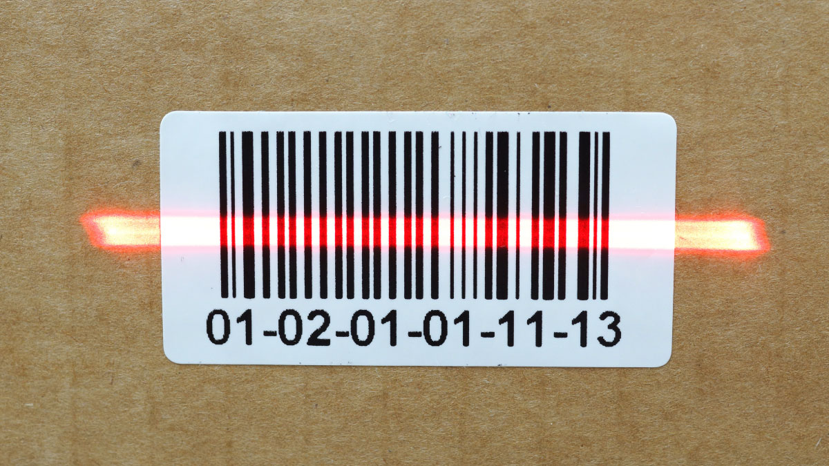 Barcode on a box being read by a handheld barcode reader.
