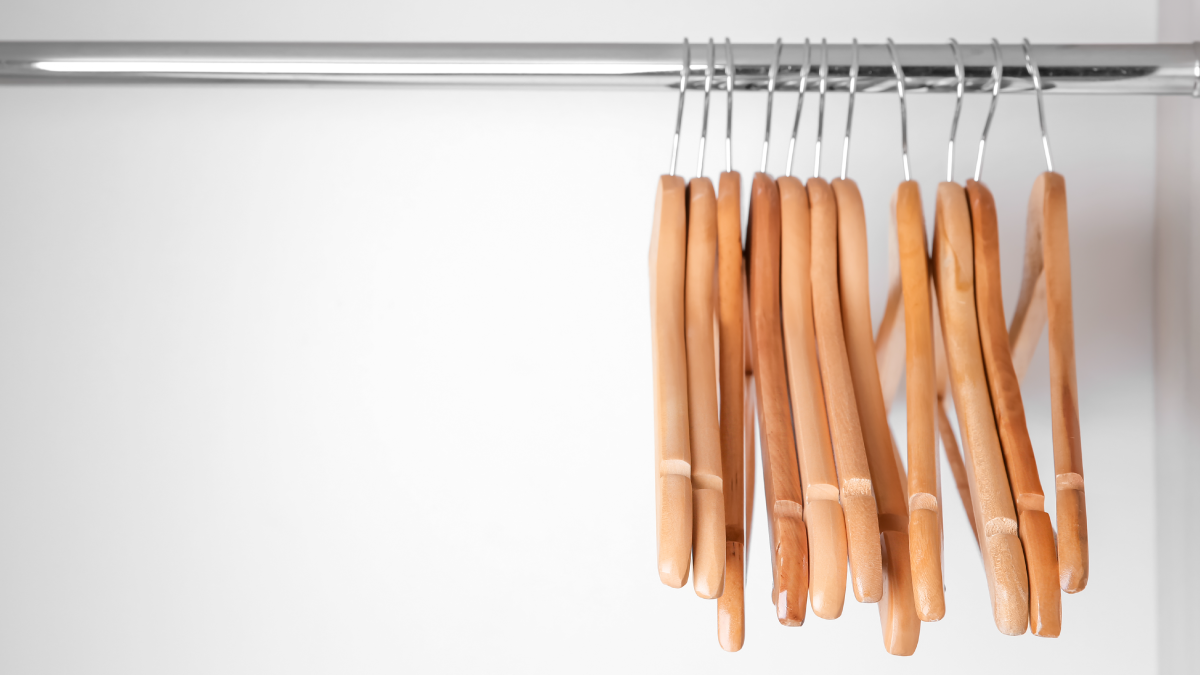 An empty boutique rack with clothing hangers.