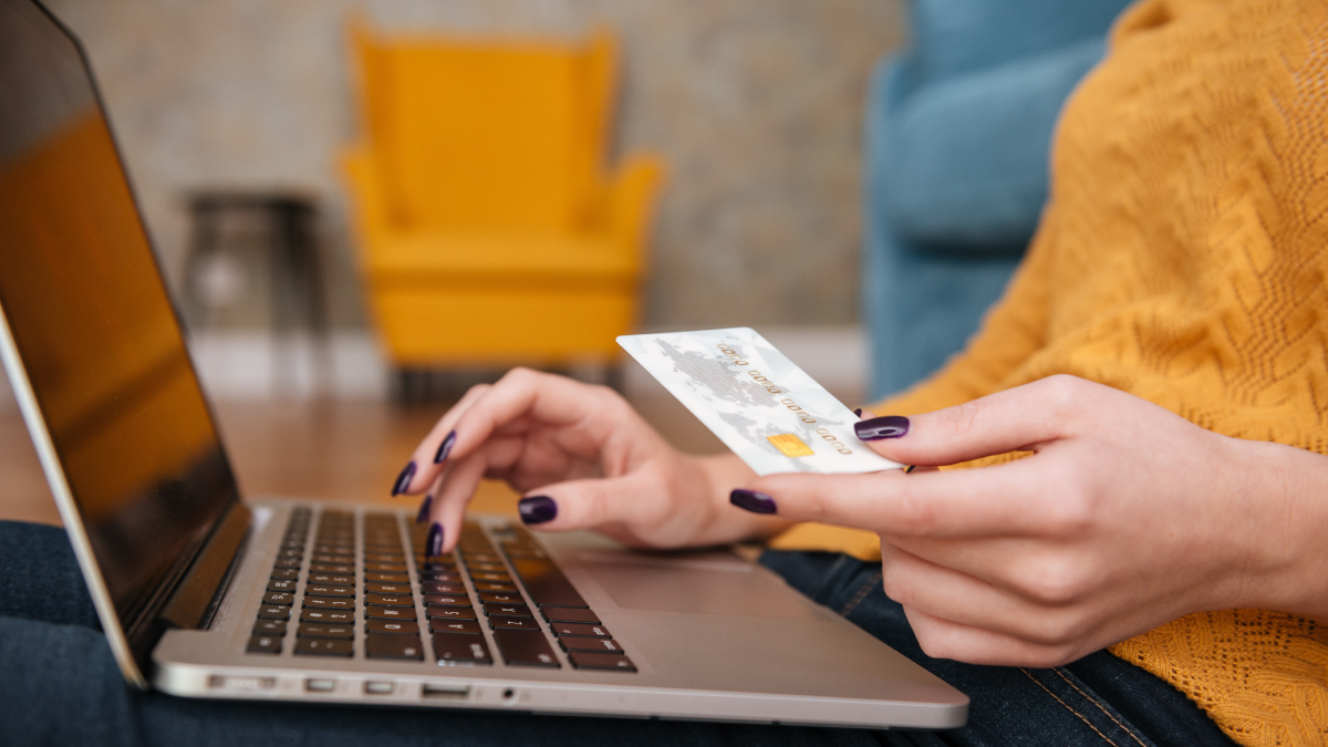 Woman typing in credit card number to make an online purchase- free shipping provided.