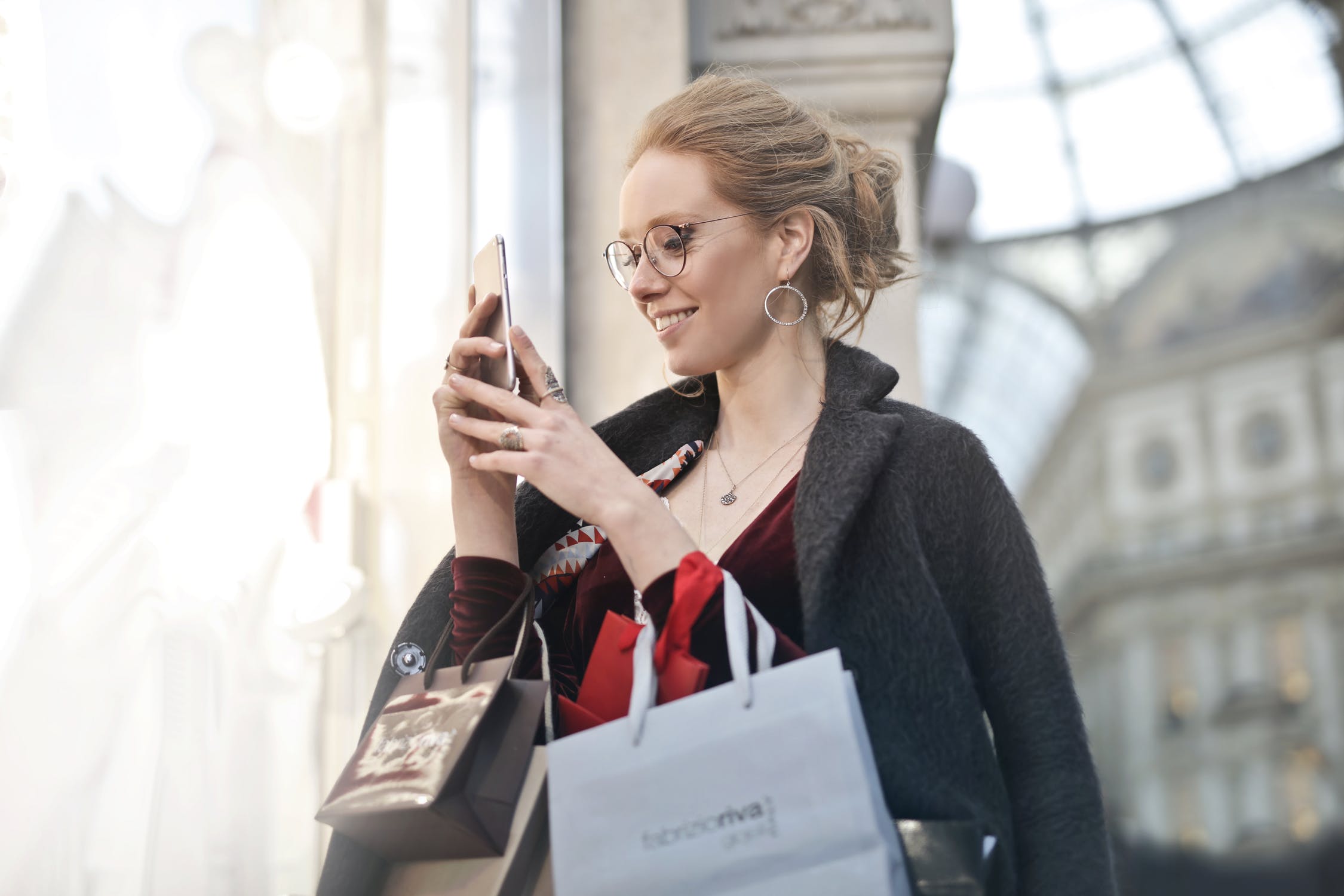 Woman shops in brick and mortar as well as through mobile apps.