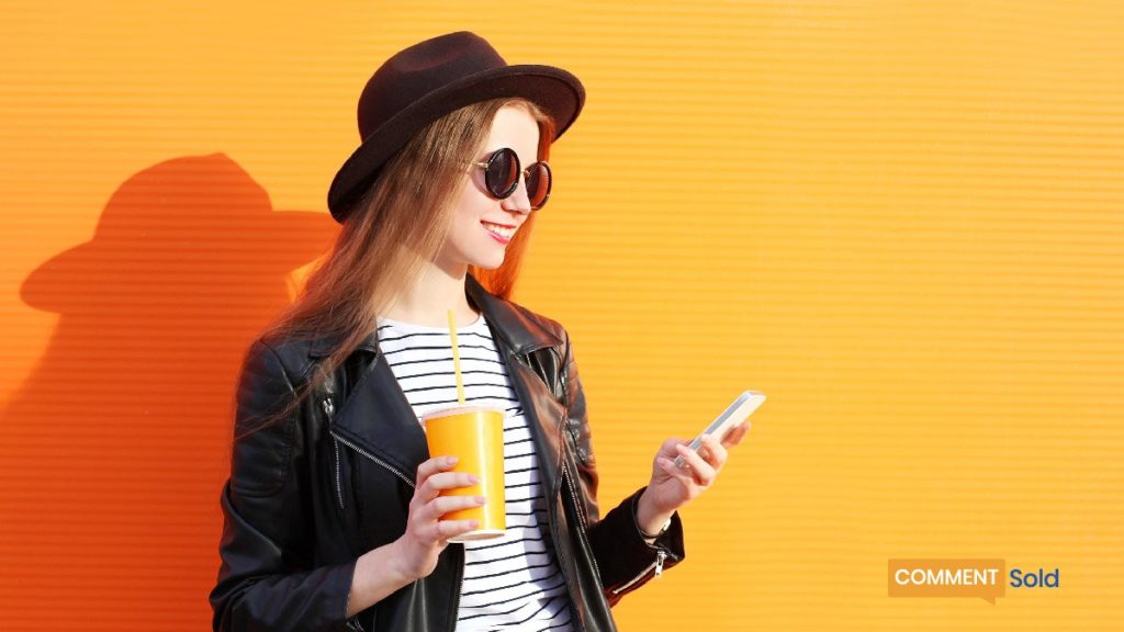 woman smiling at mobile phone with yellow background