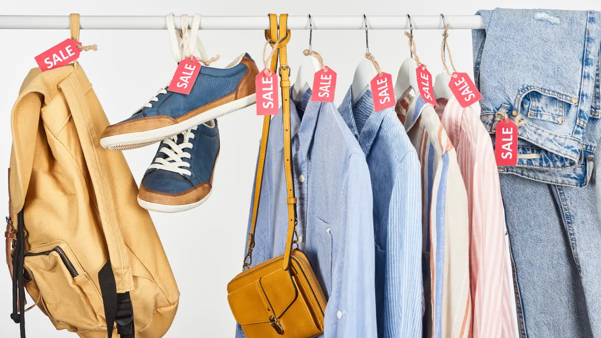 Clothing, shoes, and accessories hanging on an end of year sale rack.