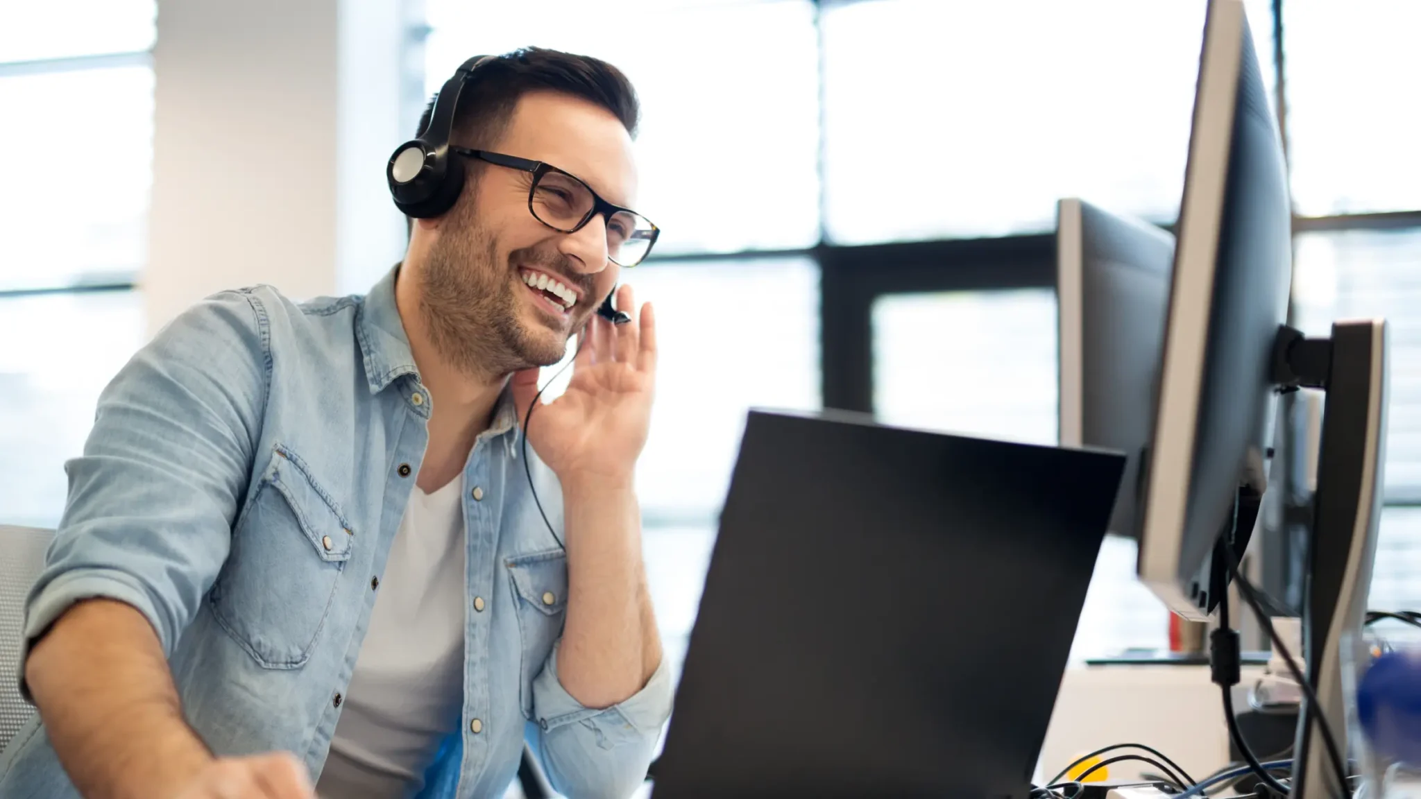 Smiling woman sitting on her laptop acts as a customer service rep for an online fashion retailer.